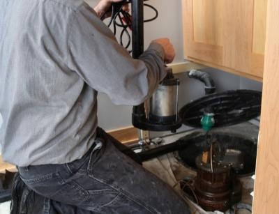 person performing maintenance on a sump pump